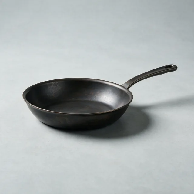 A carbon steel frying pan with a long handle