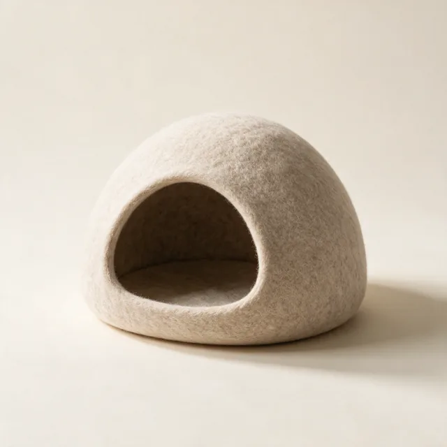 A covered cat cave bed in felted oatmeal wool