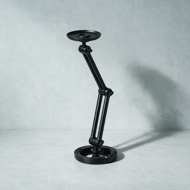 A folded matte black monitor arm with its desk clamp